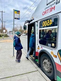 Two people getting on the Metro Bus Route 7.